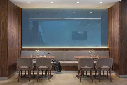 a dining room with four chairs and a large window at Hotel Milan in Pula