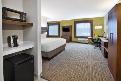a hotel room with a bed and a desk at Holiday Inn Express Hotel & Suites Manchester Conference Center by IHG in Manchester