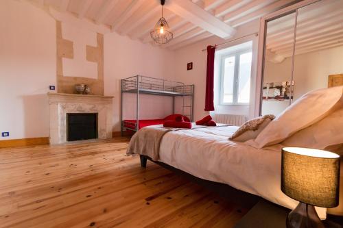 a bedroom with a large bed and a fireplace at La ferme de Fumichon in Tour-en-Bessin