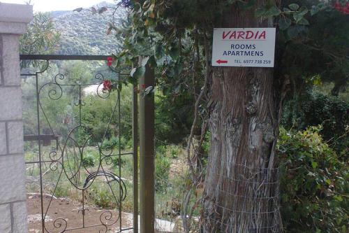 a sign on a gate next to a tree at Vardia rooms & apartments in Mikros Gialos