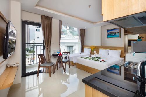 a hotel room with two beds and a table and chairs at XO Hotel & Apartments in Nha Trang