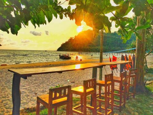 einen Tisch und Stühle am Strand mit Meerblick in der Unterkunft I-Lay House Koh Kood in Ko Kood