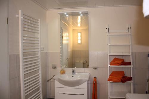 a white bathroom with a sink and a mirror at Ferienwohnung Rothirsch in Bad Sachsa