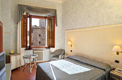 a hotel room with a bed and a window at Leon Bianco in San Gimignano