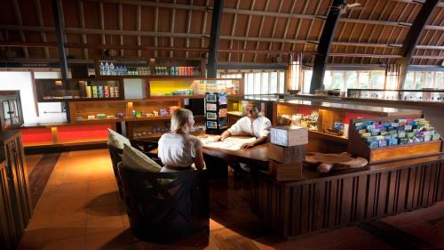 a man and a woman sitting at a bar at Holiday Inn Resort Vanuatu by IHG in Port Vila