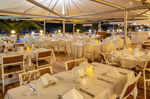 a banquet hall with white tables and chairs at Mark Warner Phokaia Beach Resort in Foca