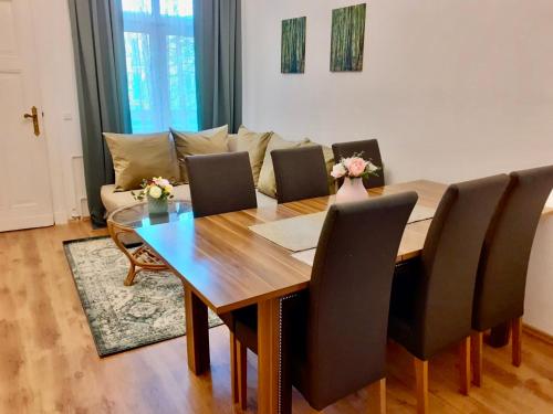 a dining room table with chairs and a couch at Ferienwohnungen am Ruppiner See und Fontane Therme in Neuruppin
