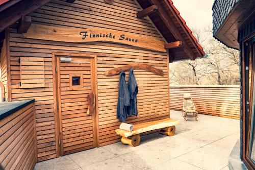a wooden sauna with a bench in front of it at Erlebnishotel "Zur Schiffsmühle" GmbH in Höfgen