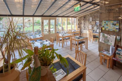 a restaurant with tables and chairs and plants at Greycroft B&B in Alnwick