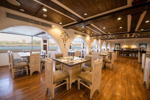 a restaurant with tables and chairs and a view of the ocean at SUNRISE Mahrousa Cruise in Luxor