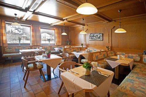 a restaurant with tables and chairs in a room at Hotel Untermetzger in Zell am Ziller