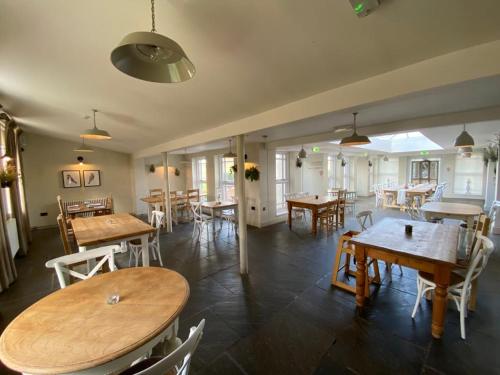 a dining room with wooden tables and chairs at Kedleston Country House B&B in Derby