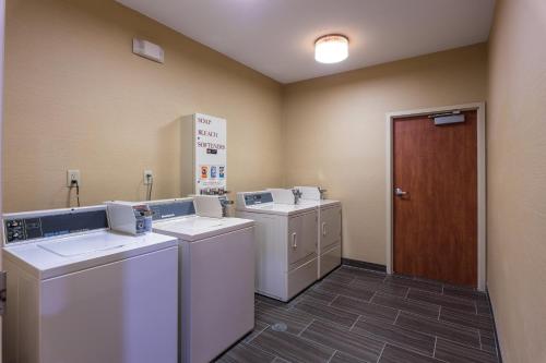 エドモンドにあるHoliday Inn Express Hotel & Suites Edmond by IHGの洗濯機とドア付きのランドリールーム