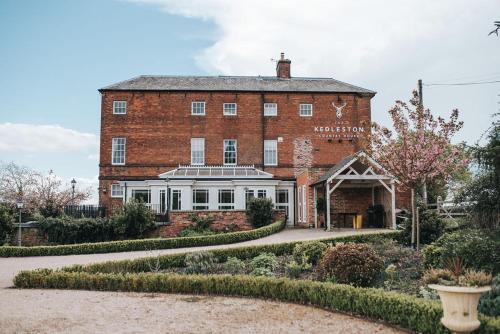 a large brick building with a garden in front of it at Kedleston Country House B&B in Derby