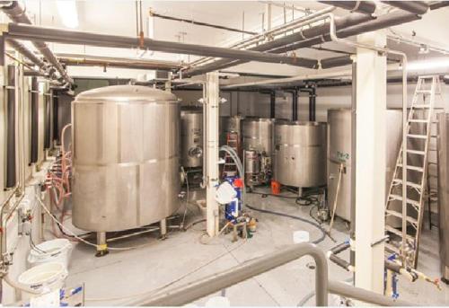 a brewery with a bunch of silver tanks at Woodstock Inn, Station and Brewery in North Woodstock
