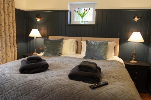 a bedroom with a bed with two towels on it at Cwmbach Lodge luxury B&B in Glasbury