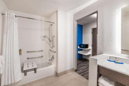 a bathroom with a tub shower and a sink at Holiday Inn Express & Suites Lake Havasu - London Bridge, an IHG Hotel in Lake Havasu City