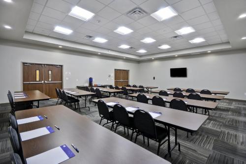 an empty classroom with tables and chairs and a screen at Holiday Inn Express & Suites - Houston NASA - Boardwalk Area by IHG in Seabrook