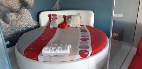 - un lit rouge et blanc dans une chaise blanche dans l'établissement Naturiste Cap d'Agde Villa Port Nature 201, au Cap d'Agde