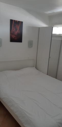 カップ・ダグドにあるPort Ambonne 239の壁に絵が描かれた部屋の白いベッド1台