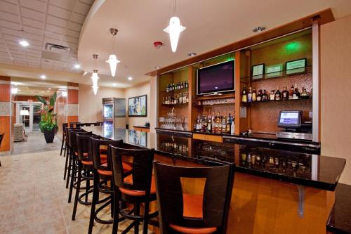 a bar with a row of chairs in a restaurant at Holiday Inn Hotel & Suites Gateway by IHG in Williamsburg