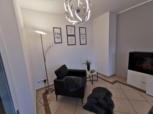 a living room with a black chair and a television at Luxuriöses Wellnes Apartment in Bad Essen