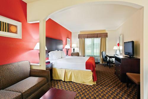 a hotel room with a bed and a couch at Holiday Inn Express & Suites Malvern by IHG in Malvern