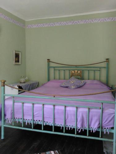 a bedroom with a bed with a purple blanket at Traditional stone house in Pelion in Rodhiás