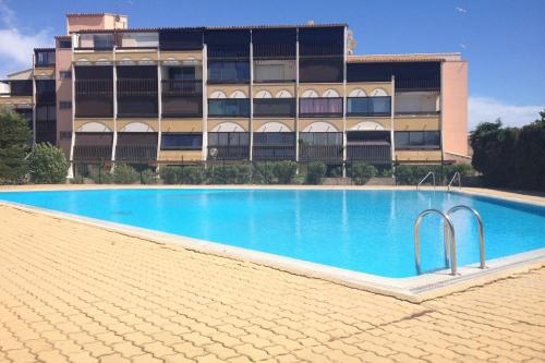 une piscine vide en face d'un bâtiment dans l'établissement Naturiste Cap d'Agde Port Vénus 104, au Cap d'Agde