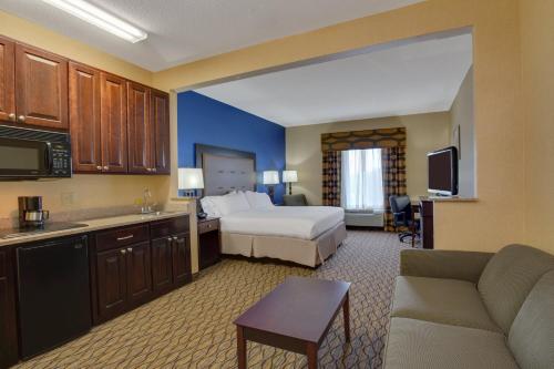 a large hotel room with a bed and a couch at Holiday Inn Express Tower Center New Brunswick by IHG in East Brunswick