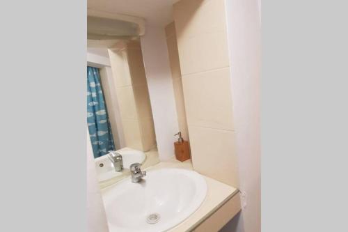 ein weißes Badezimmer mit Waschbecken und Spiegel in der Unterkunft appartement renové , quartier historique du panier , centre-ville in Marseille