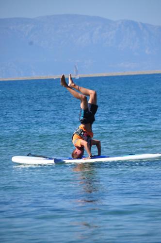 two people on a surfboard in the water at Mark Warner Phokaia Beach Resort in Foca