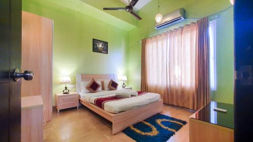 a bedroom with a bed with green walls and a window at Rainforest Resort and Spa, Igatpuri -Nature's Luxury Awaits in Igatpuri