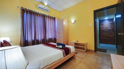 a bedroom with a bed and a window and a door at Rainforest Resort and Spa, Igatpuri -Nature's Luxury Awaits in Igatpuri