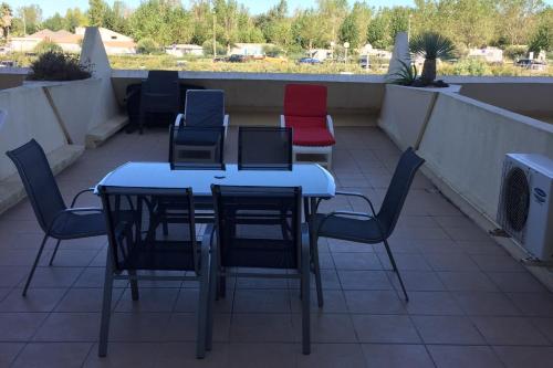 un grupo de sillas y mesas en un balcón en Cap d'Agde Naturist Héliopolis K 106, en Cap d'Agde
