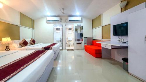 a hotel room with two beds and a red couch at Rainforest Resort and Spa, Igatpuri -Nature's Luxury Awaits in Igatpuri