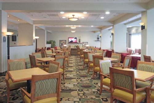a dining room with wooden tables and chairs at Holiday Inn Express & Suites Monterrey Aeropuerto by IHG in Monterrey