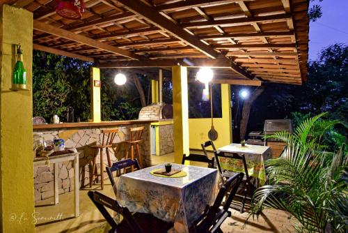 a patio with a table and chairs and a kitchen at Chalés Natora in Lençóis