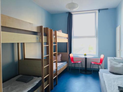 a bedroom with bunk beds with a desk and a window at Hostel Inn-Berlin in Berlin