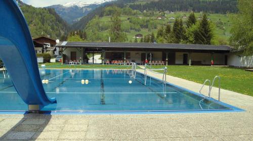 a swimming pool in front of a building at Villa Zeppelin - App Bergkristall in Bramberg am Wildkogel