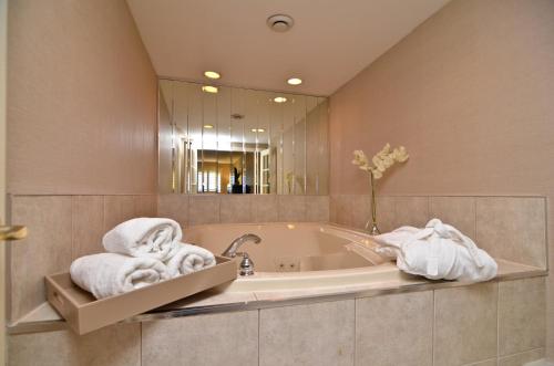 W łazience znajduje się wanna z ręcznikami i lustrem. w obiekcie Holiday Inn Hotel & Suites St.Catharines-Niagara, an IHG Hotel w mieście St. Catharines