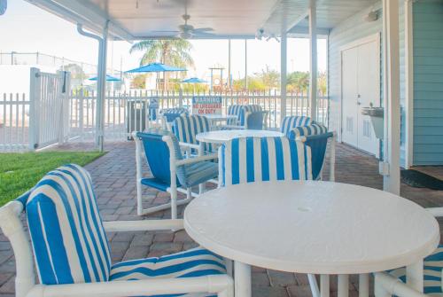 a patio area with chairs, tables and umbrellas at Villas at Fortune Place in Kissimmee