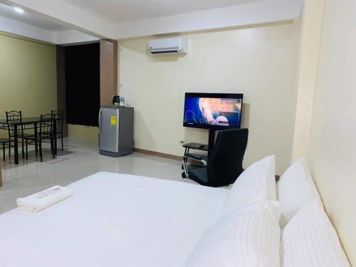 ein Schlafzimmer mit einem Bett und einem TV in einem Zimmer in der Unterkunft Red Palm Inn studio room with Netflix in Baybay
