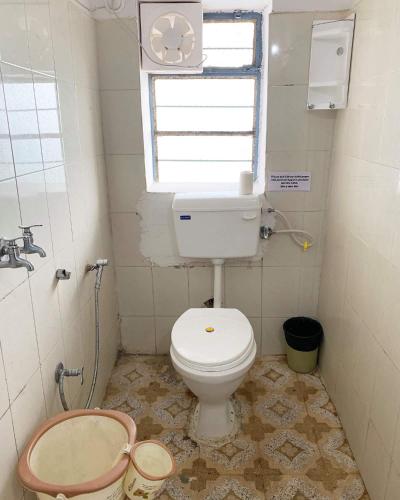 a small bathroom with a toilet and a window at IL Padrino hotel in Pushkar