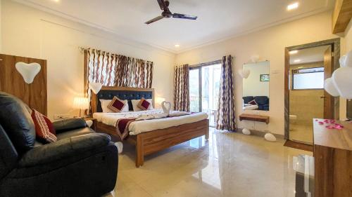 a bedroom with a bed and a couch in a room at Rainforest Resort and Spa, Igatpuri -Nature's Luxury Awaits in Igatpuri
