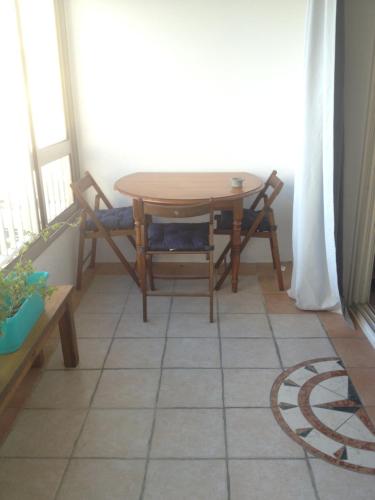 uma mesa e cadeiras num quarto com uma janela em Appartement vue mer em Six-Fours-les-Plages