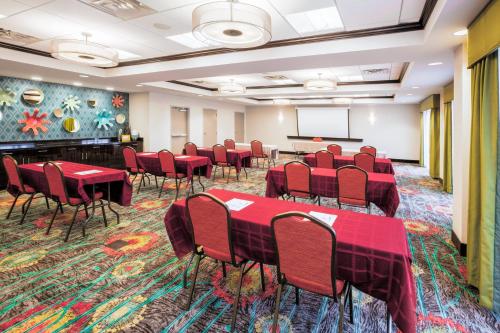 a conference room with red tables and chairs and a screen at Holiday Inn Express & Suites Eureka by IHG in Eureka