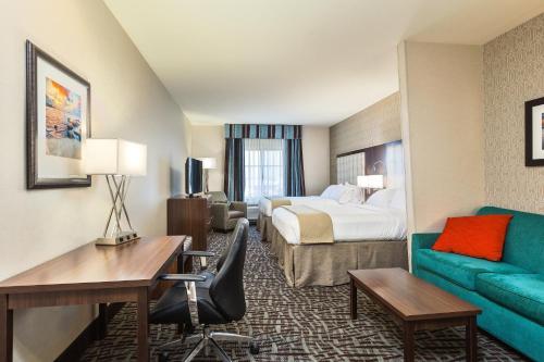 a hotel room with a bed and a desk and a couch at Holiday Inn Express & Suites Eureka by IHG in Eureka