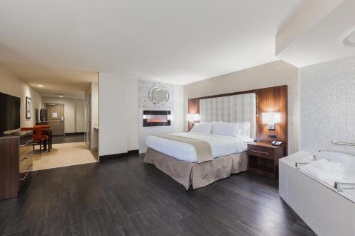 a hotel room with a bed and a bathroom at Holiday Inn Express & Suites Eureka by IHG in Eureka