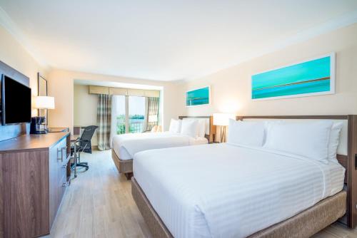 a hotel room with two beds and a flat screen tv at Holiday Inn Express & Suites Nassau by IHG in Nassau